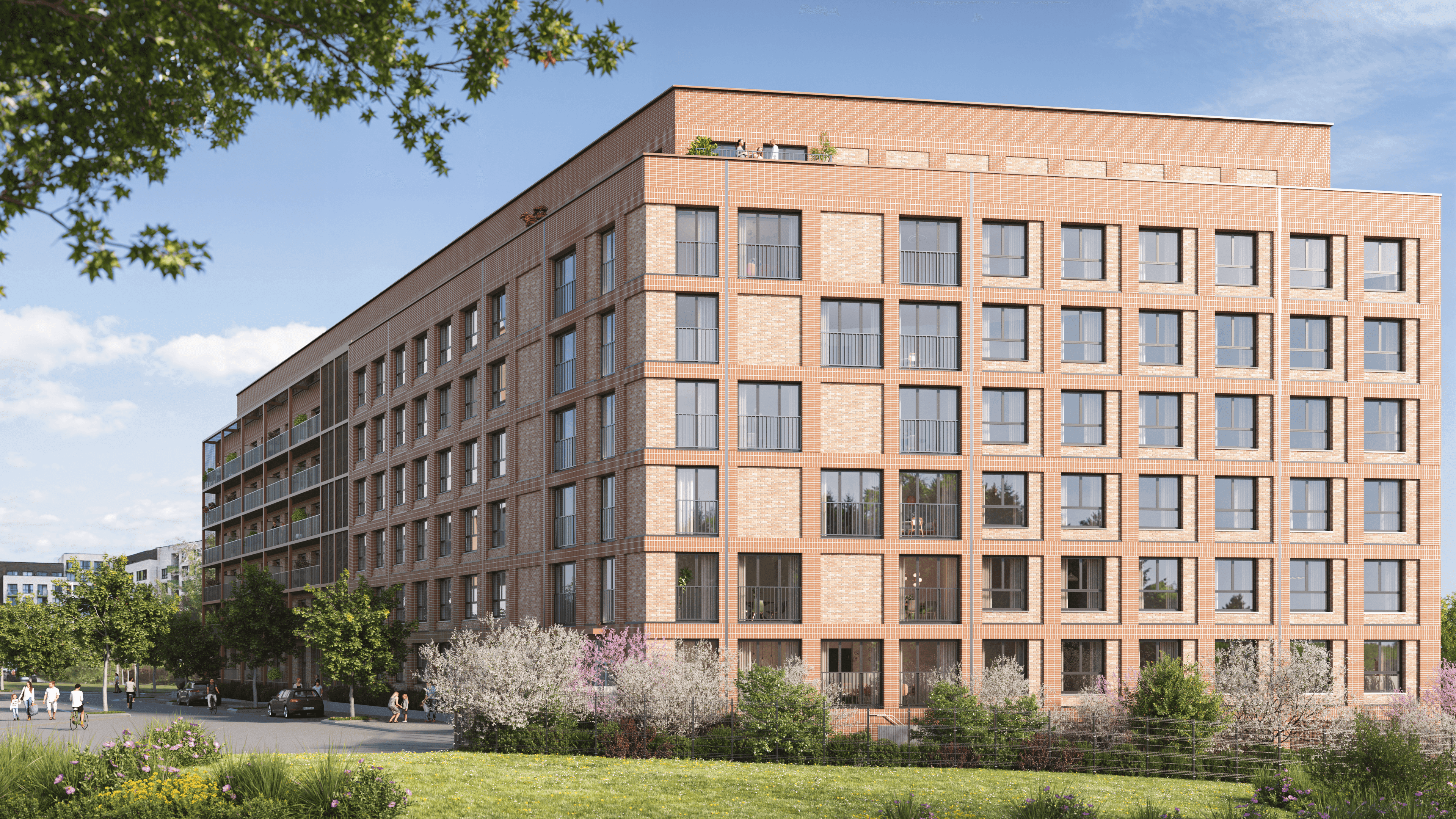 Grande résidence neuve en briques bicolores avec balcons et terrasse en toiture, entourée d'espaces verts fleuris dans un quartier résidentiel calme en Belgique.